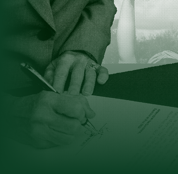 A man writing on a piece of paper with a pen.
